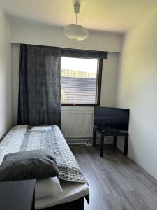 un dormitorio con una cama y una ventana en Guest House Julia- Cozy Stay in Kajaani, en Kajaani