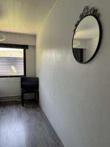 espejo en una pared en una habitación con silla en Guest House Julia- Cozy Stay in Kajaani, en Kajaani