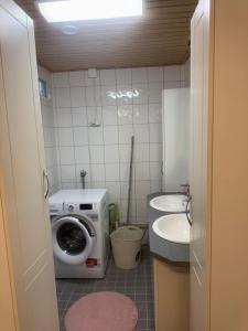 Un pequeño baño con lavadora y lavabo. en Guest House Julia- Cozy Stay in Kajaani, en Kajaani 2 fotos más