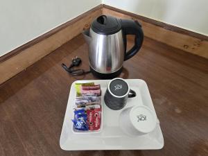 a coffee pot and a tray with food and drinks at Snow Leopard By Tranquility Stays in Tabo