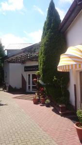 a building with an umbrella on a brick sidewalk at Motel Eden in Zamość