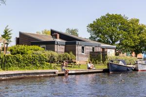 ヘーグにあるWaterherberg It Beakenの水辺の桟橋に座る人々 +25枚の写真