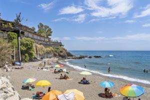 Leute am Strand mit Sonnenschirmen und dem Meer in der Unterkunft Rooftop Torrequebrada Holiday Apartment in Torremuelle