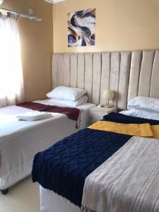 a bedroom with two beds and a couch and a window at Kalahari in Sekoma