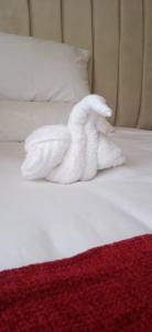 a white towel animal laying on a bed at Kalahari in Sekoma +2 photos