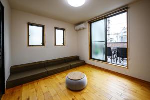 Una sala de estar con un sofá y una ventana grande. en まちなかの家MANA, en Ishigaki Island