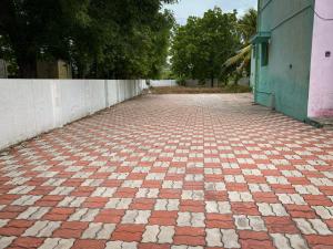 an empty brick road next to a wall at Butterfly Blossom Villa in Samayapuram