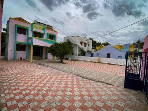 een bakstenen weg voor een groep huizen bij Butterfly Blossom Villa in Samayapuram