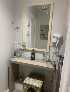 a bathroom with a mirror and a hair dryer at Celebrating or Relaxing 5-star farm stay with spa and more! in Kirk of Shotts