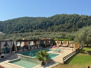 a villa with a swimming pool and a mountain at Summer Senses in Vourvourou in Vourvourou