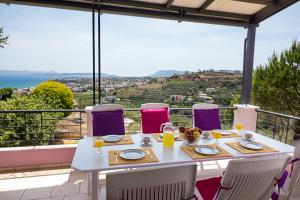 a white table and chairs on a balcony with a view at Villa Anatoli in Stalos