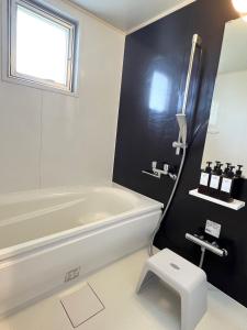 a bathroom with a white tub and a sink at アラハブルーリゾート in Chatan +18 photos