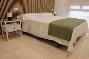 ein Schlafzimmer mit einem weißen Bett, einem Nachttisch und einem Bett der Marke sidx sidx sidx. in der Unterkunft Casa Rural La Tajuela in Bohonal de Ibor