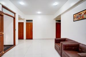 uma sala de estar com um sofá e algumas portas em Super Collection O Kalyan Nagar Formerly Prime Square em Bangalore