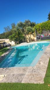 a swimming pool with blue water in a yard at Havre de Paix in Nîmes