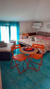 a room with two chairs and a table and a bed at Casa Blu with Sea View - Borgo Stays in Sperlonga