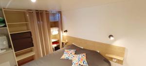 a small room with a bed and an open closet at Cozy-House tout confort camping 4 étoiles in Lège-Cap-Ferret +23 photos