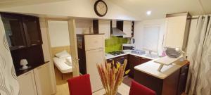 a kitchen with a counter and a clock on the wall at Cozy-House tout confort camping 4 étoiles in Lège-Cap-Ferret