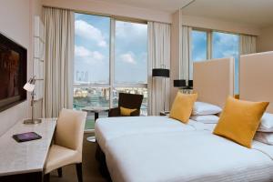 a hotel room with two beds and a desk and window at Centro Al Manhal by Rotana in Abu Dhabi