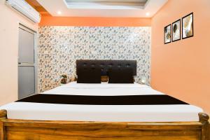 una camera da letto con un letto con una parete arancione di Super Hotel O Dakshin Dwar Formerly Radha Krishna Niwas a Puri