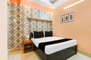 una camera con letto e parete piastrellata di Super Hotel O Dakshin Dwar Formerly Radha Krishna Niwas a Puri