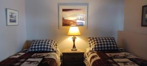 a bedroom with two beds and a lamp on a night stand at Deer Ridge B&B in Golden