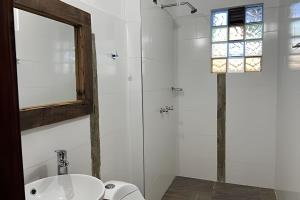 a white bathroom with a sink and a mirror at Casa de montaña con vista, BBQ y wifi confiable in Subachoque +11 photos