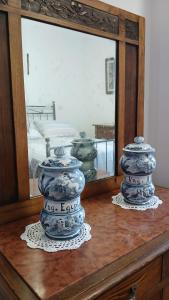 two blue and white vases sitting on a table in front of a mirror at Casa storica di Sant'Andrea by Italita in Calamandrana