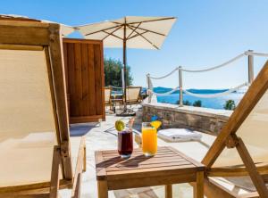 Una mesa con una bebida y una sombrilla en un patio. en Apartments Villa Capitano, en Mlini