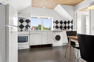 a kitchen with a washer and dryer and a table at Døssinghus Holiday Apartments in Kjellerup