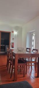 a dining room with a wooden table and chairs at Quinta do José - AL in Praia da Vitória