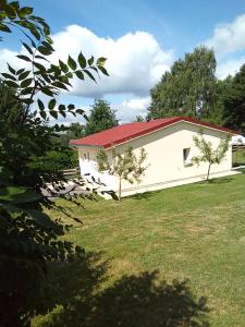 a small white building with a red roof at La CHANTERELLE in Mortagne
