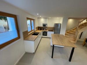 una cucina con un tavolo di legno e una scala di Maison Climatisée Coeur Historique Blagnac a Blagnac