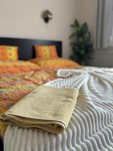 a bed with two towels sitting on top of it at Termál Apartman in Tiszaújváros