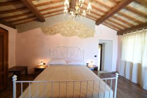 a bedroom with a large bed with a chandelier at Agriturismo " La Valle degli Ulivi" in Vacri