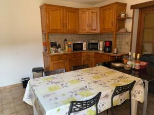 una cocina con mesa y sillas y una cocina con armarios de madera. en Dormez dans la chambre du meunier !, en Germolles-sur-Grosne