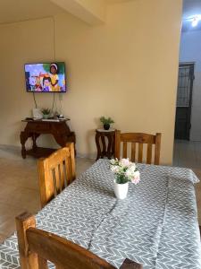 una sala da pranzo con un tavolo e una tv di Mango Home Iguazú a Puerto Iguazú