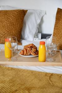 Una bandeja con un plato de pasteles y vasos de zumo de naranja. en 542 Suite Montrouge - Appartement proche de Paris, en Montrouge