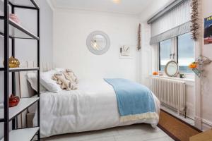 プレストウィックにあるSea Front Holiday & Corporate Let Accommodationのベッドと窓のある白い寝室