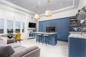 a blue kitchen with a couch and a table at Sea view Villa Holiday and Corporate Let Accommodation in Prestwick