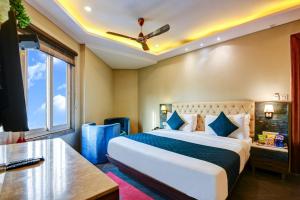 a bedroom with a bed and a desk and a window at The IVY Grand Hotel - 5 Minutes from Connaught Place and New Delhi Railway Station With Free Secured Parking in New Delhi +111 photos