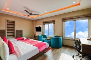 a bedroom with two beds and a desk and windows at The IVY Grand Hotel - 5 Minutes from Connaught Place and New Delhi Railway Station With Free Secured Parking in New Delhi