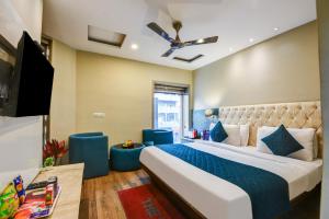 a bedroom with a large bed and a tv at The IVY Grand Hotel - Luxury living in City Centre Near Connaught Place in New Delhi