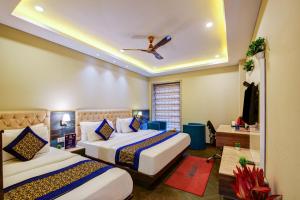 a bedroom with two beds and a ceiling fan at The IVY Grand Hotel - Luxury living in City Centre Near Connaught Place in New Delhi