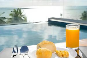a plate of food and a glass of orange juice at Flat à beira-mar Infinity at the Sea - MyFlats Hospedagens in João Pessoa