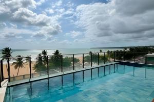 a swimming pool with a view of the beach at Flat à beira-mar Infinity at the Sea - MyFlats Hospedagens in João Pessoa
