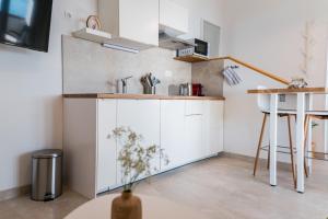 a kitchen with white cabinets and a table at Apartment Eva in Murter
