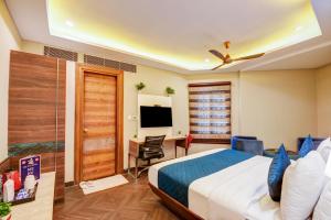 a bedroom with a bed and a desk and a television at The IVY Grand Hotel - 5 Minutes from Connaught Place and New Delhi Railway Station With Free Secured Parking in New Delhi
