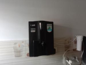a small black refrigerator sitting in a room at Family Room in Indore