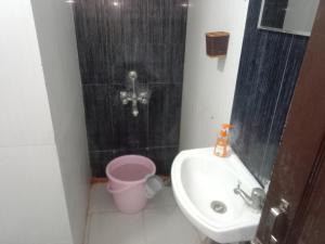 a bathroom with a sink and a toilet and a shower at Family Room in Indore